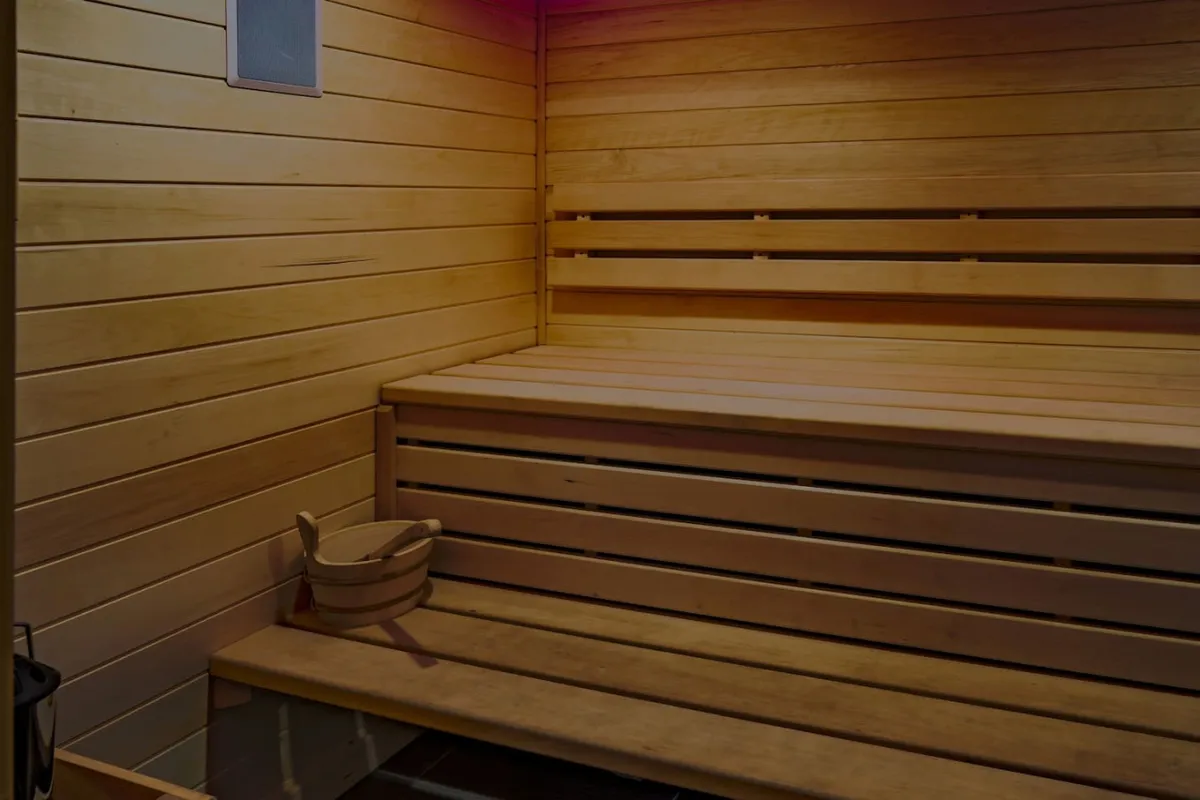 A modern private sauna with warm wooden benches and subtle detailing, designed for calming self-care and relaxation rituals. The inviting interior promises moments of rest and rejuvenation after a productive day.